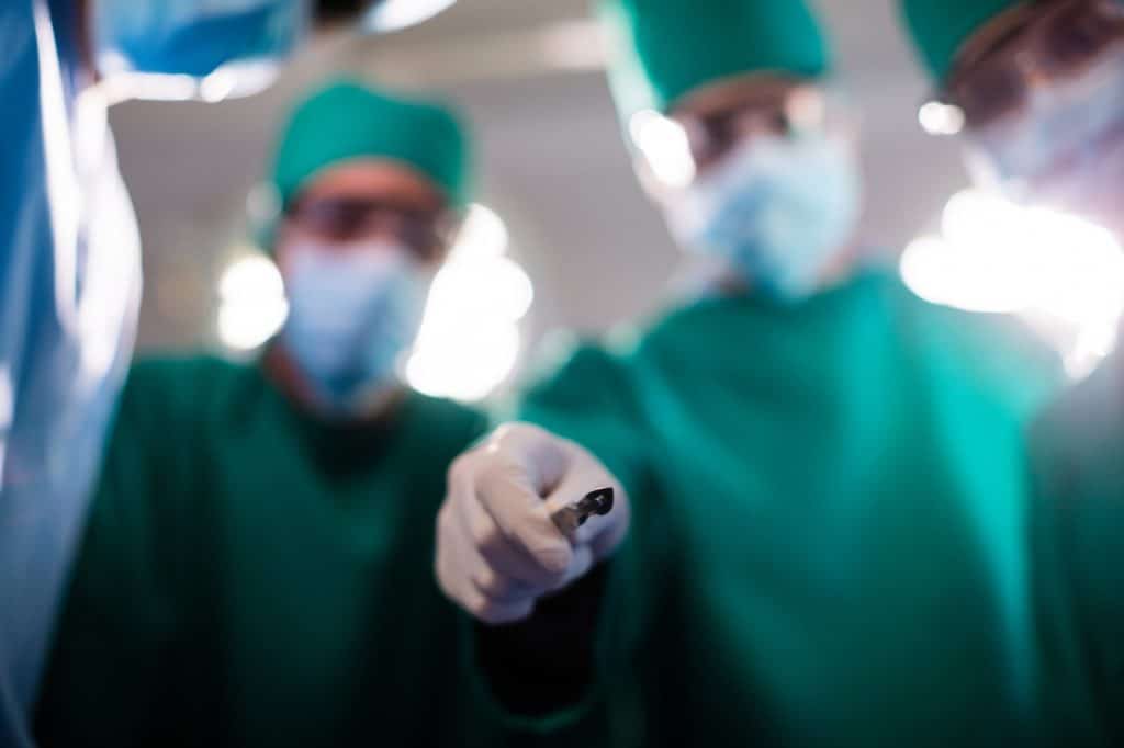 Medical team holding medical equipment in a operating room